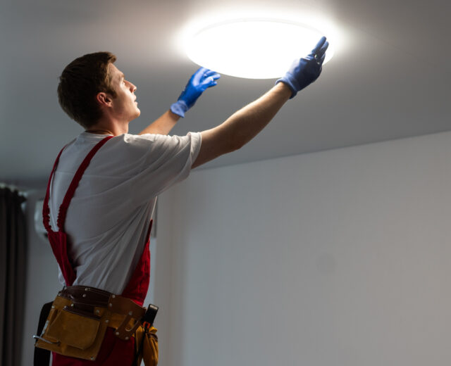 new construction electrician changing a light fixture in a florida home build.
