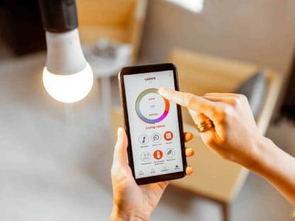Person using a smartphone app to control a living room light. The interface shows brightness and on/off options.||