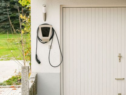 Legrand EV plugged into the wall of a house to charge an electric car.||